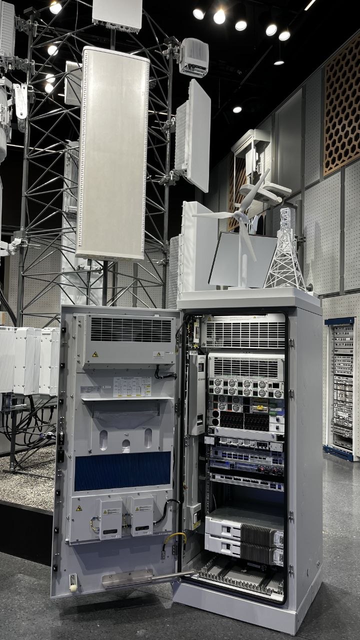 Open telecom cabinet with baseband units and green-energy scale models