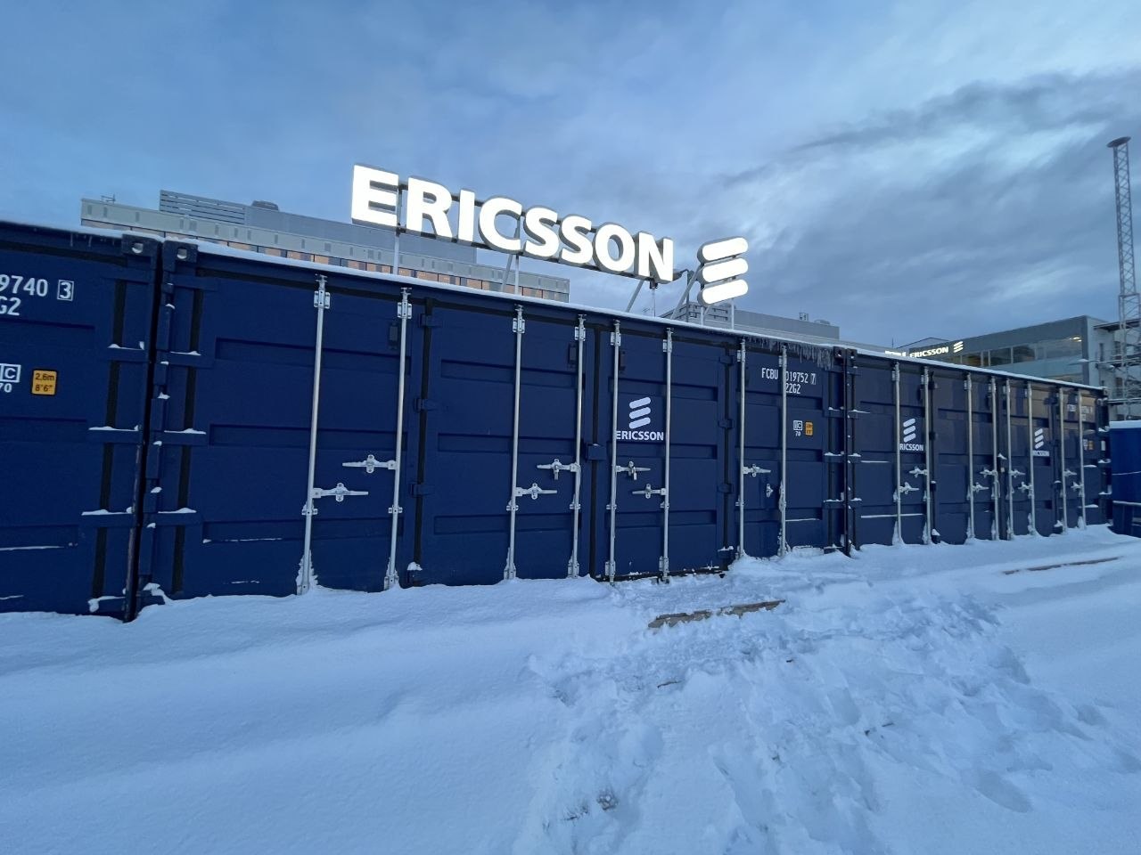 Ericsson containers under heavy snow with the illuminated sign