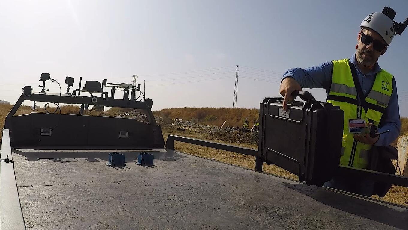 A drone pilot picking up batteries delivered by the UGV