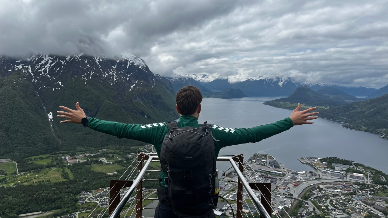 Arms wide at the Rampestreken viewpoint, 537 m above &Aring;ndalsnes with the Romsdalsfjord below