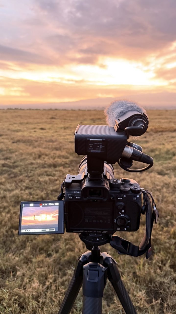 Camera rig on tripod capturing African sunrise over the savannah